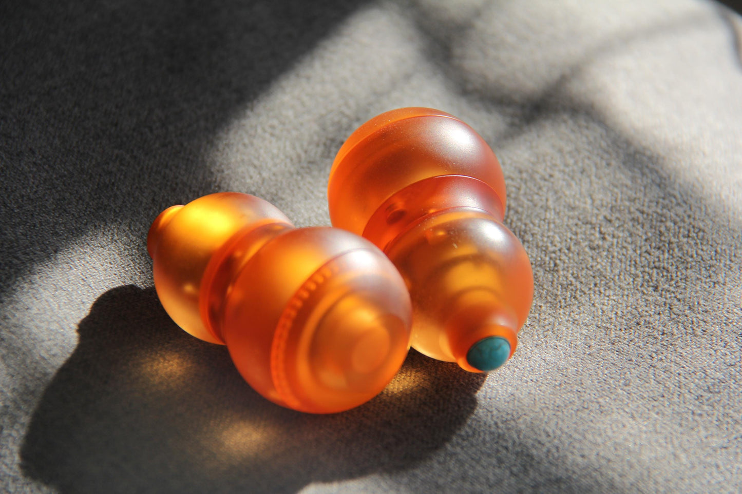 A sleek orange gourd-shaped fidget toy featuring a 4-in-1 design: magnetic push card, fidget spinner, ratchet gear, and popping coin. Highlighting its durable PMMA material, ergonomic grip, and premium quality, perfect for stress relief and focus