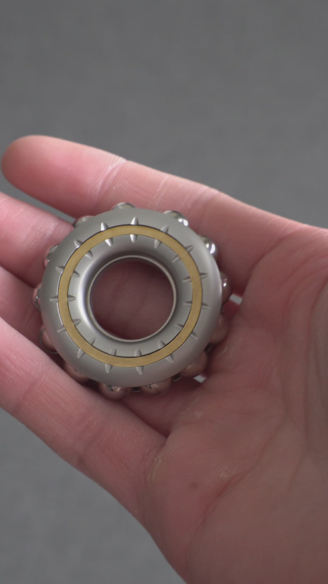 Cyber Beads magnetic spinner in hand, showing gyro spin and popping coin action.