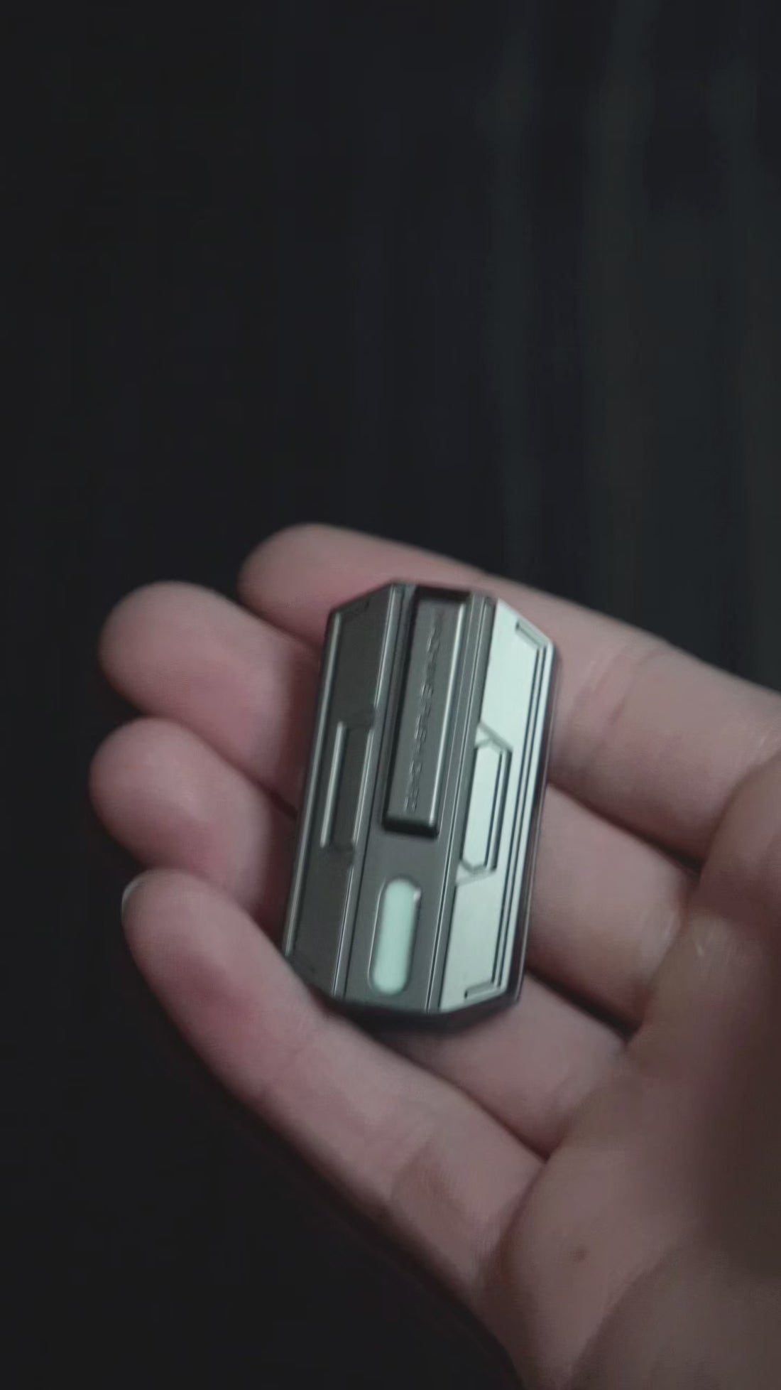 Glow slider demonstrated: magnetic push-click action with glow-in-the-dark inlay shown in low light.